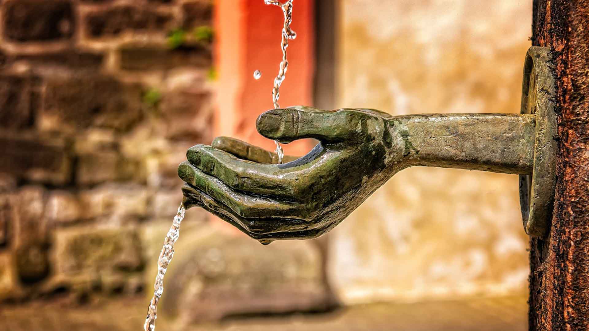 Die Superkraft von Hochsensiblen für turbulente Zeiten, Hand die Wasser aus Brunnen auffängt